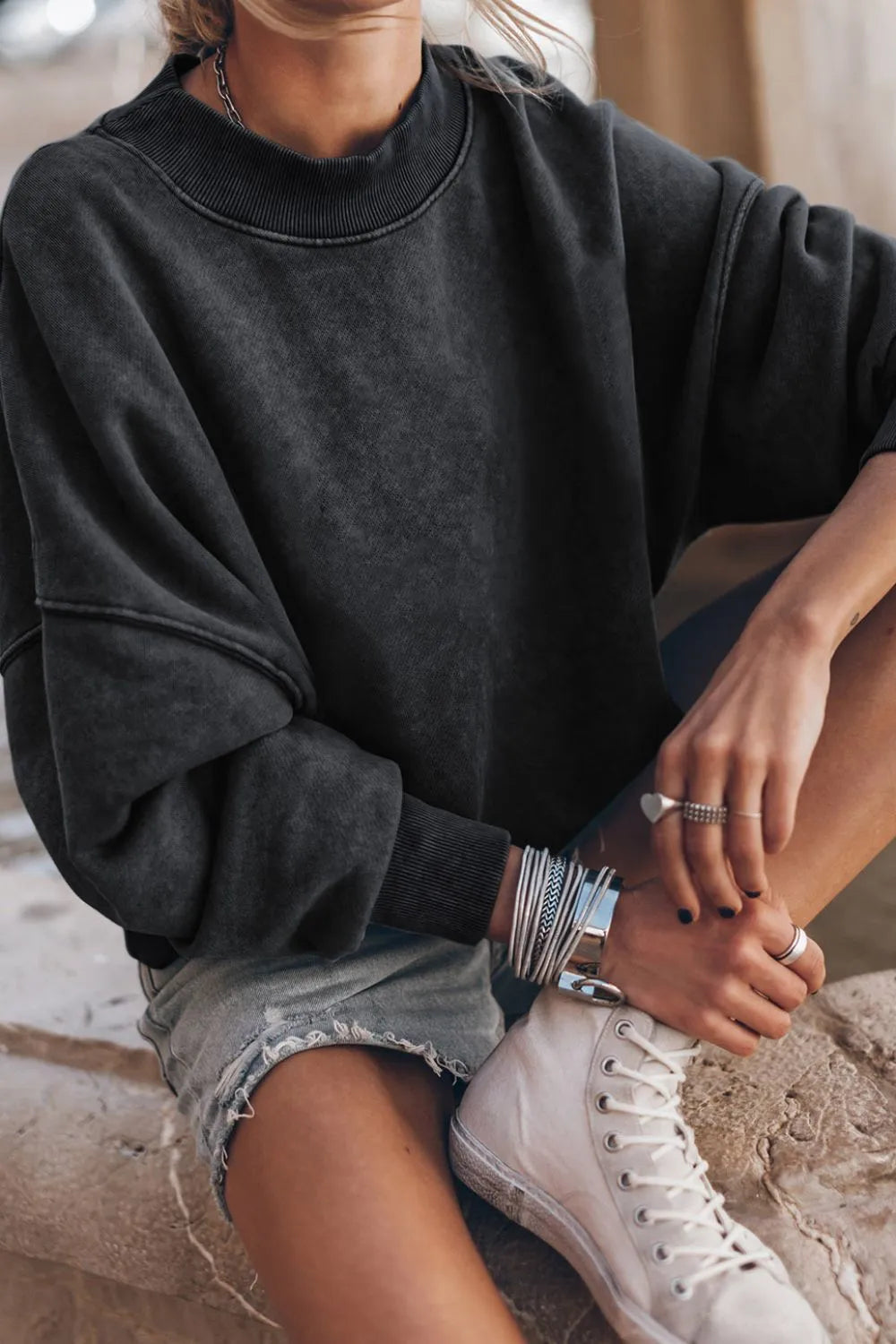 Black mock neck dropped-shoulder sweatshirt with relaxed fit and ribbed cuffs