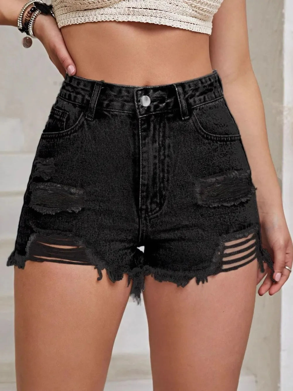 Black high-waist denim shorts with distressed rips and frayed raw hem