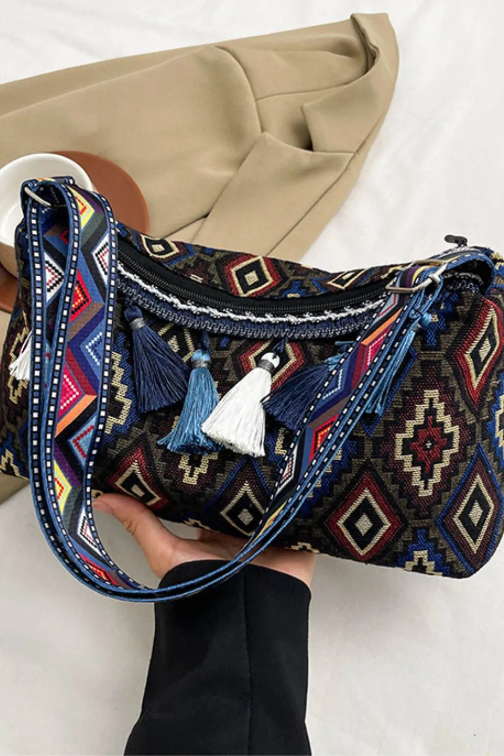 Tassel shoulder bag with navy, red, and tan geometric pattern and fringed handles