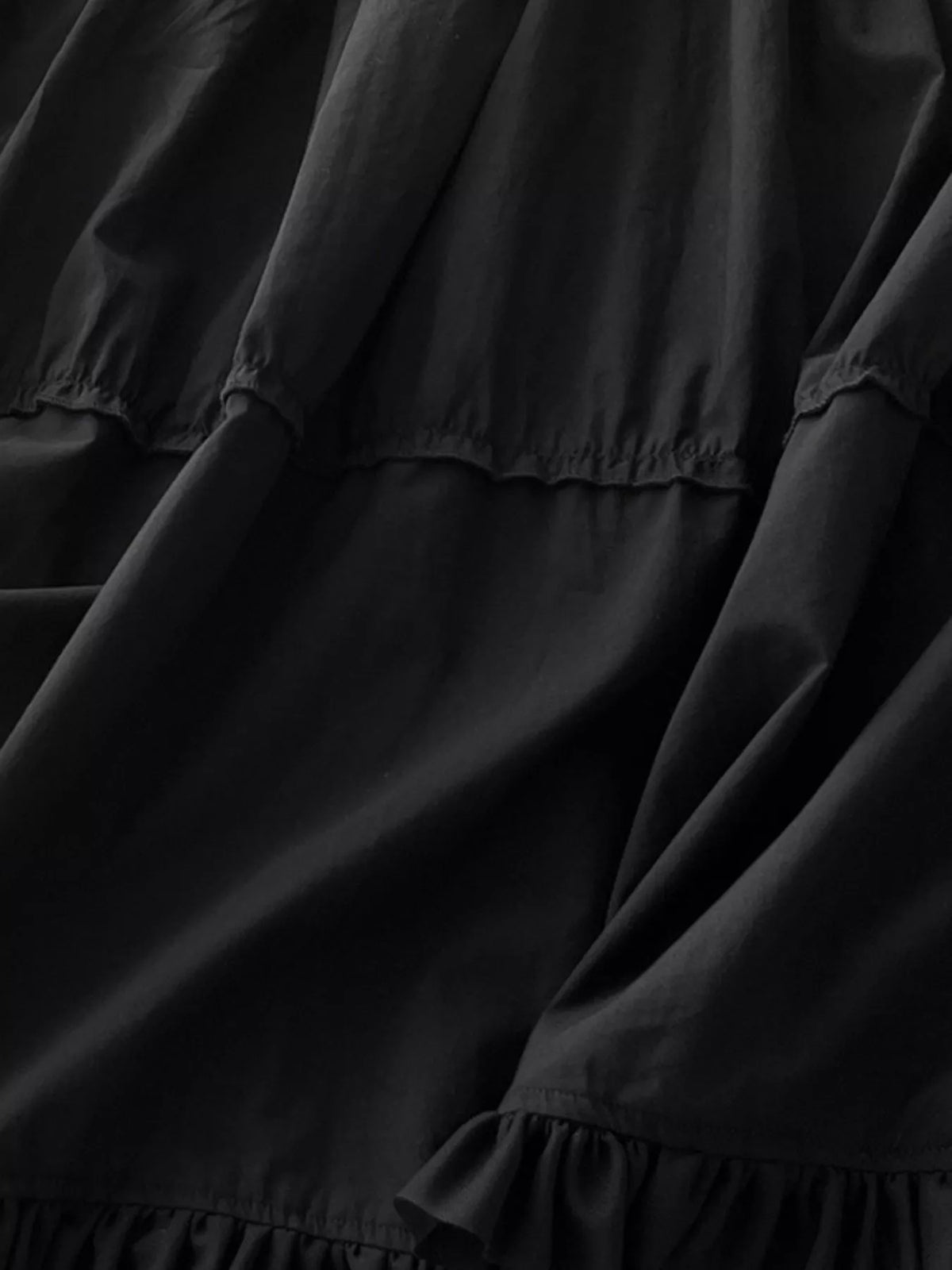 Black cotton maxi dress with ruffled square neckline and gathered tiered bodice