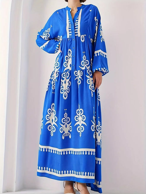 Blue long-sleeve maxi dress with white folk-style floral print and tassel trim