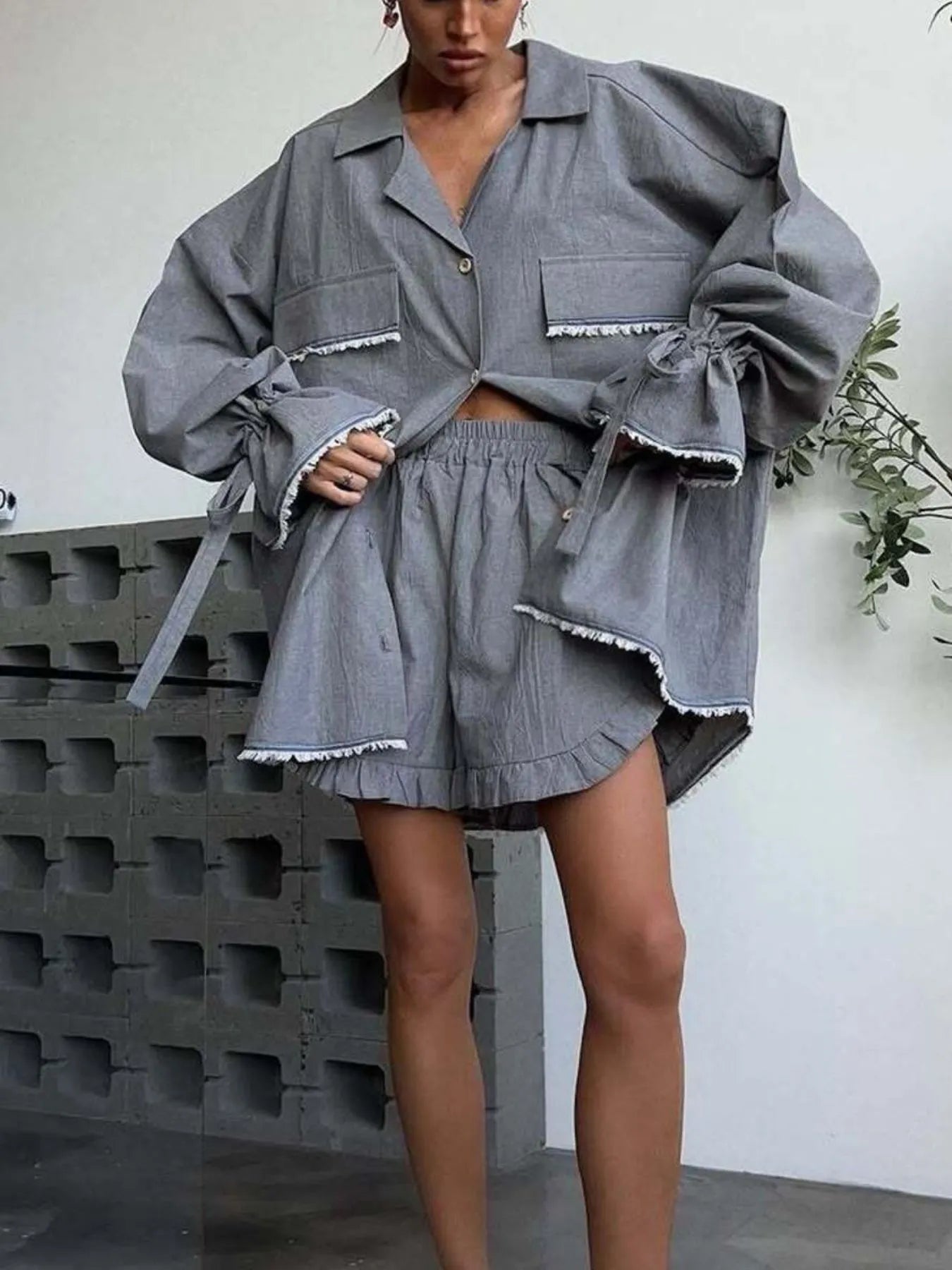 Dark gray button-up top with flounce hem and matching ruffled shorts, tie cuffs
