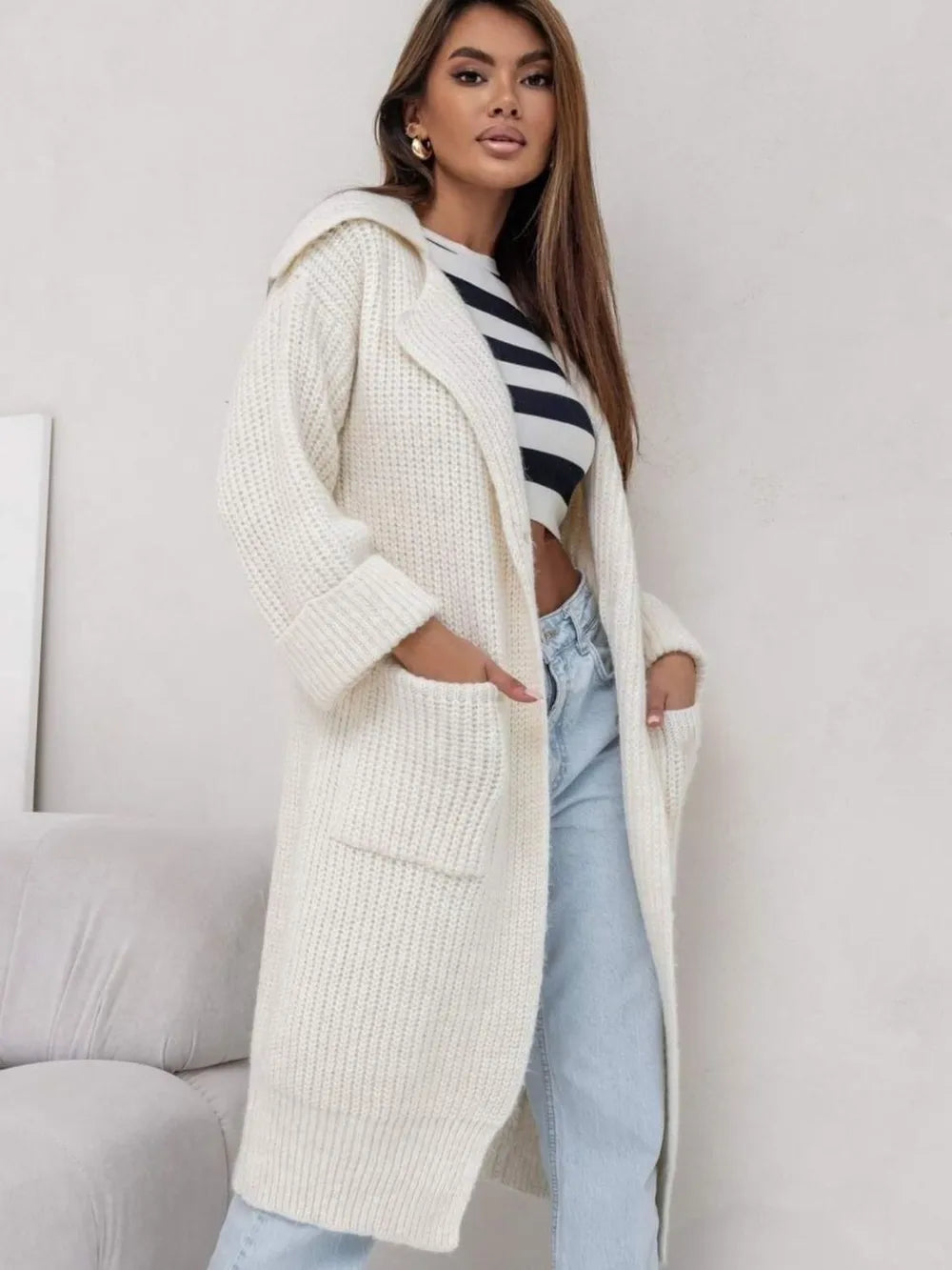 Cream long cardigan sweater with collared neck, dropped shoulders, and side pockets