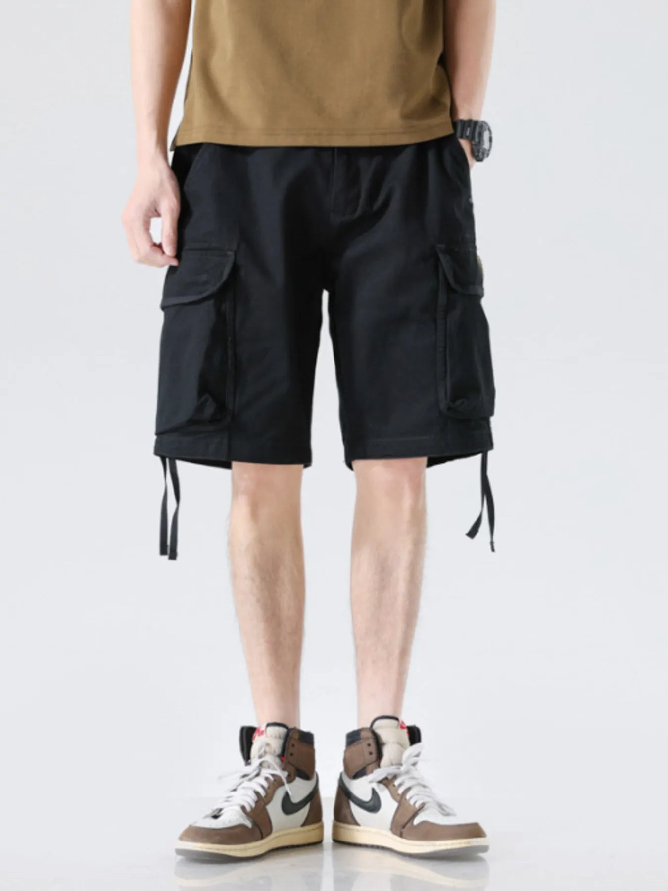 Men's black drawstring wide-leg cargo shorts with flap cargo pockets and leg ties
