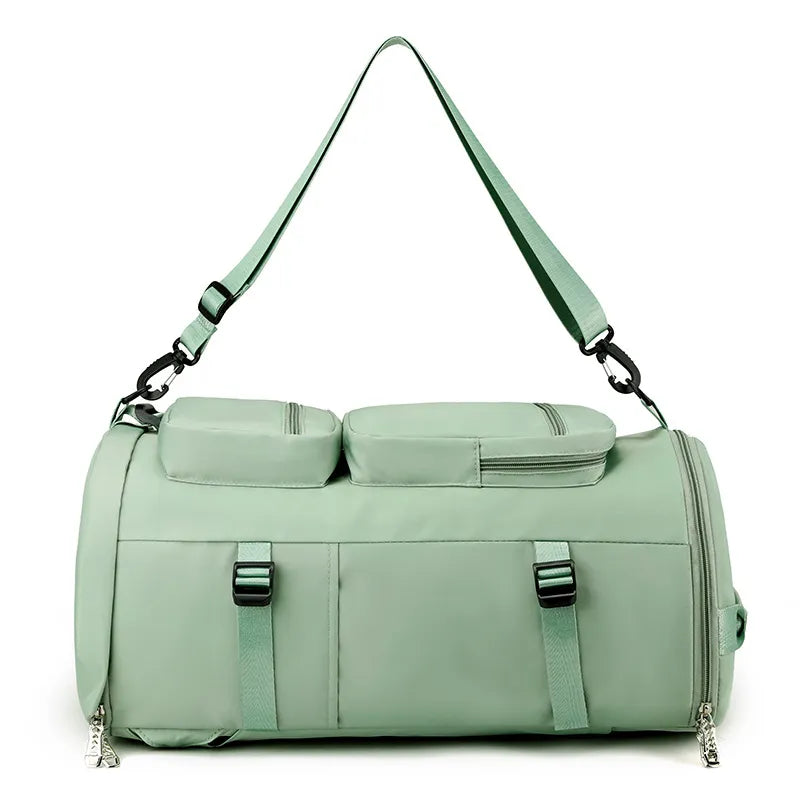 Mint green duffel-style travel backpack with two front zip pockets and adjustable shoulder straps.
