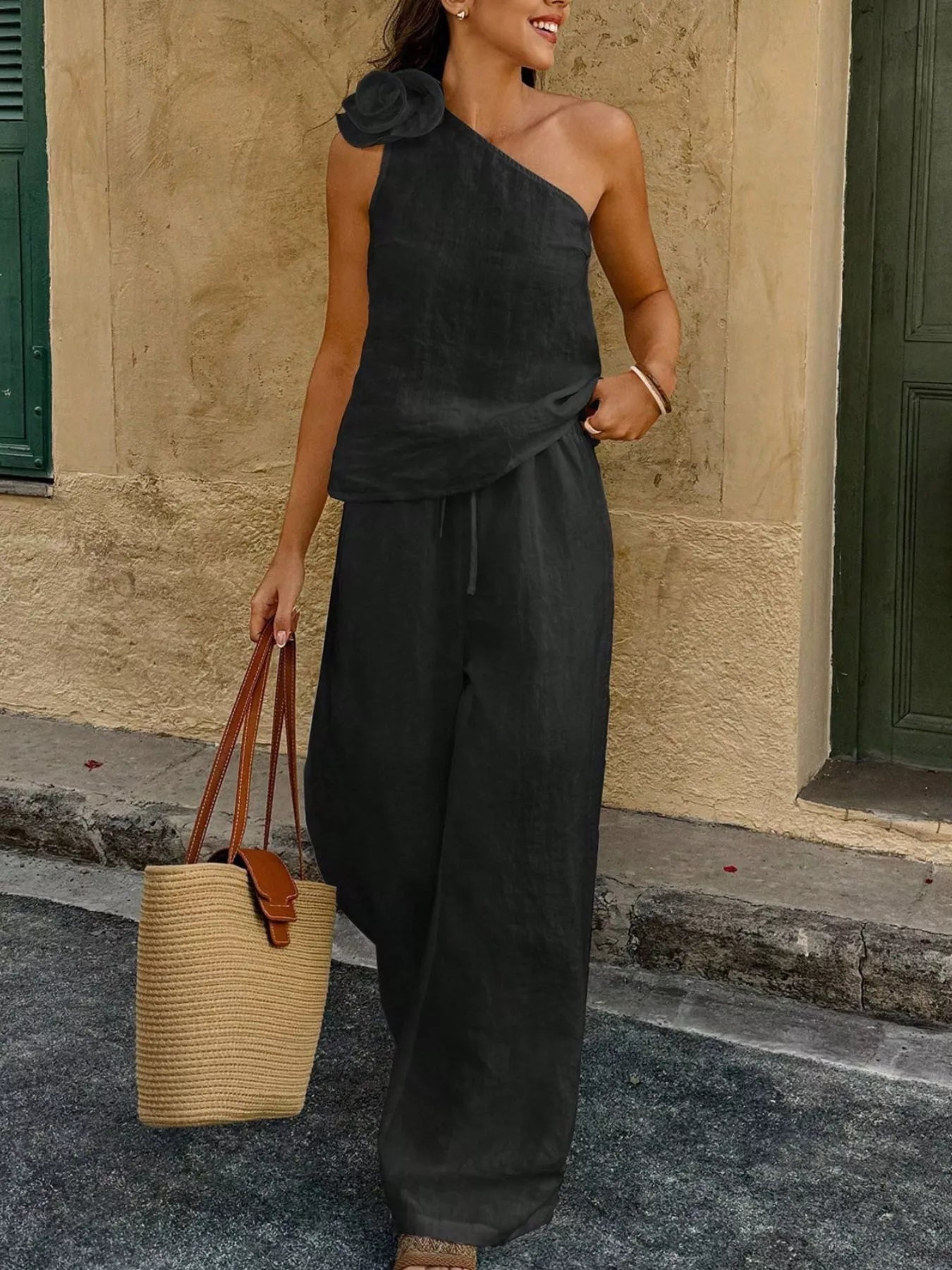 Black one-shoulder floral embellished top paired with matching wide-leg pants