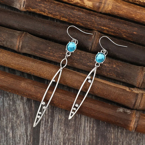 Silver-tone earrings with turquoise oval rhinestone tops and long faceted drop dangles