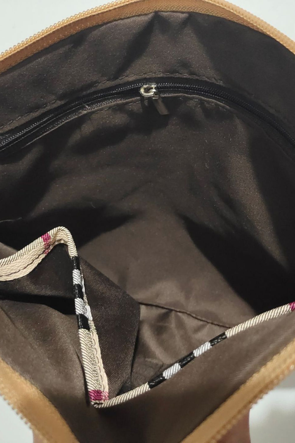 Wristlet interior lining with visible zipper and metal pull