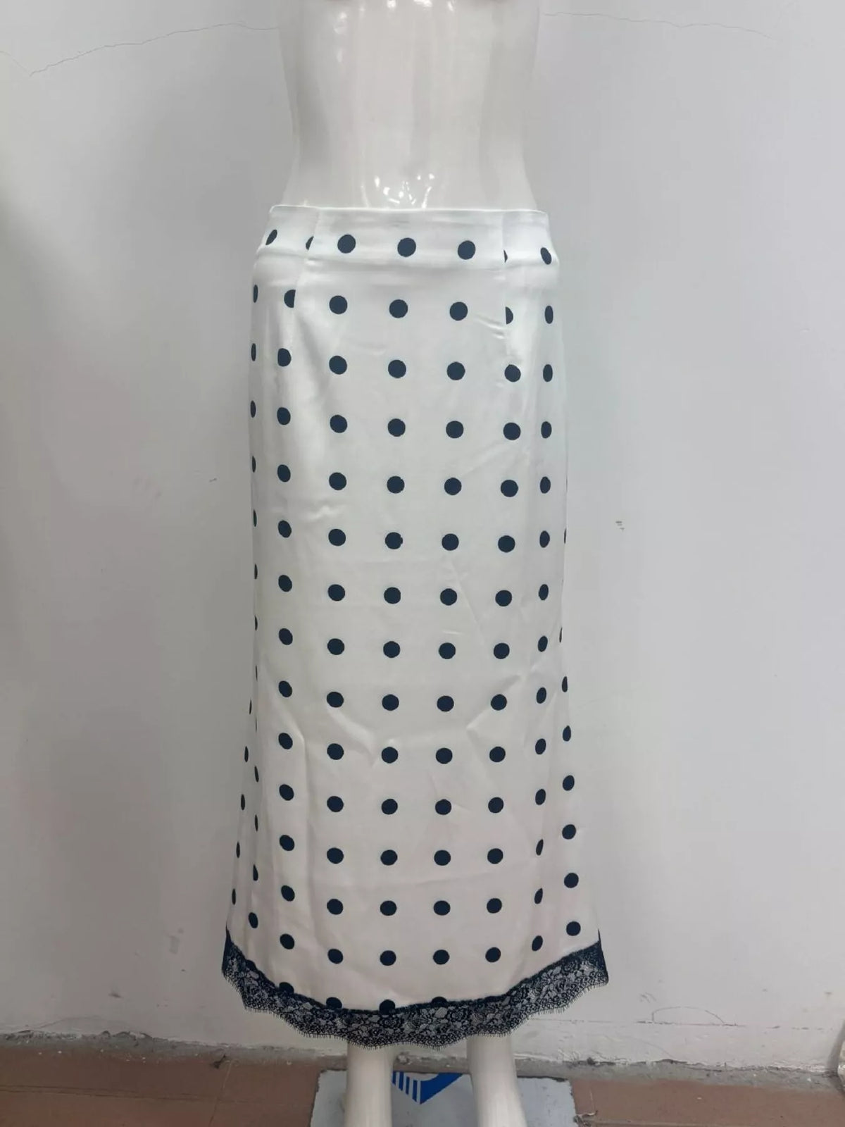 Light white midi skirt with blue polka dots and dark lace hem trim