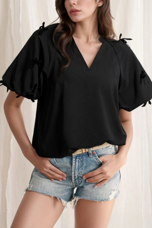 Black puff-sleeve blouse with bow-tied sleeve details and V-neck front