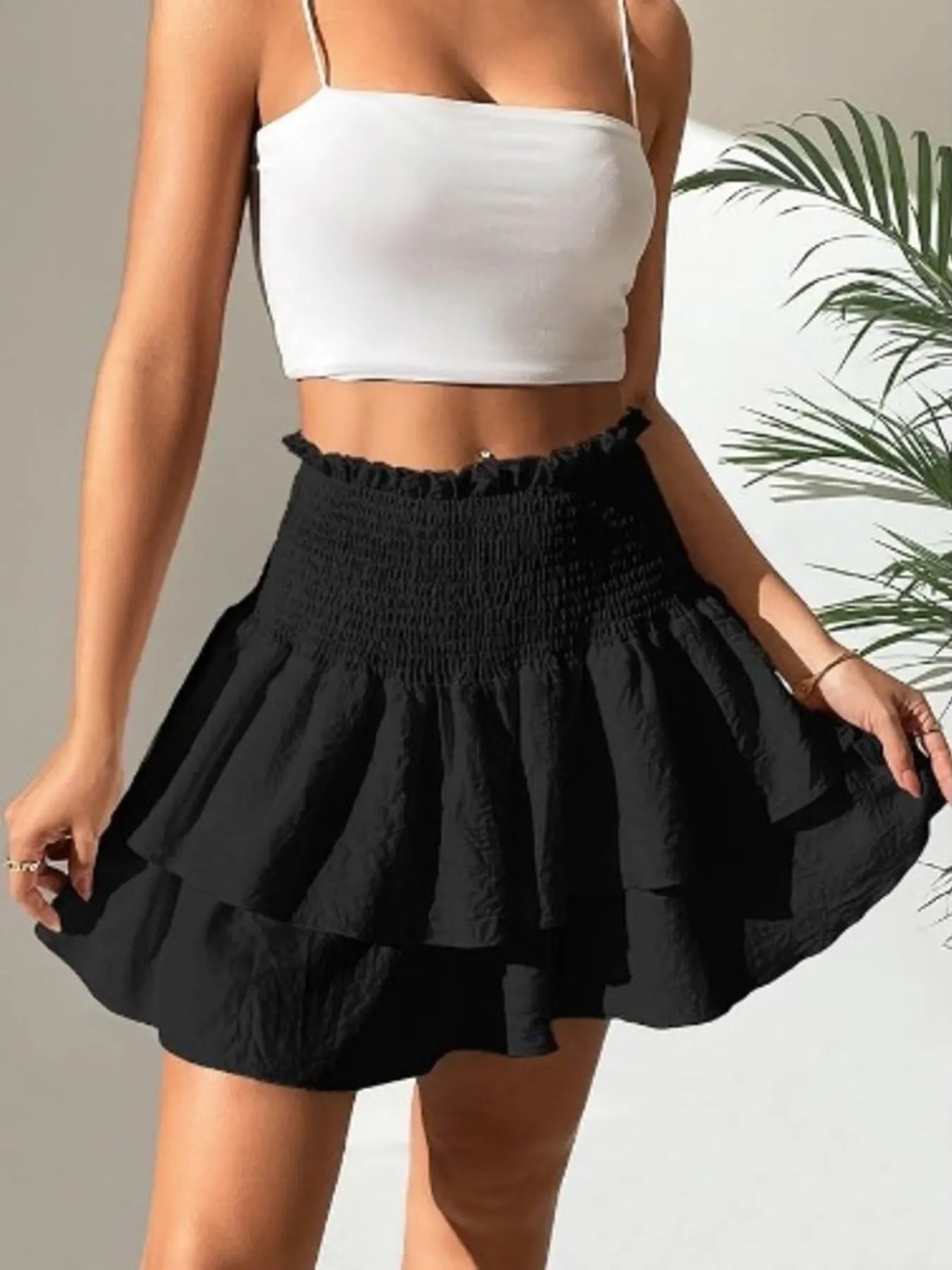 Black smocked layered mini skirt with gathered waist and tiered ruffle hem