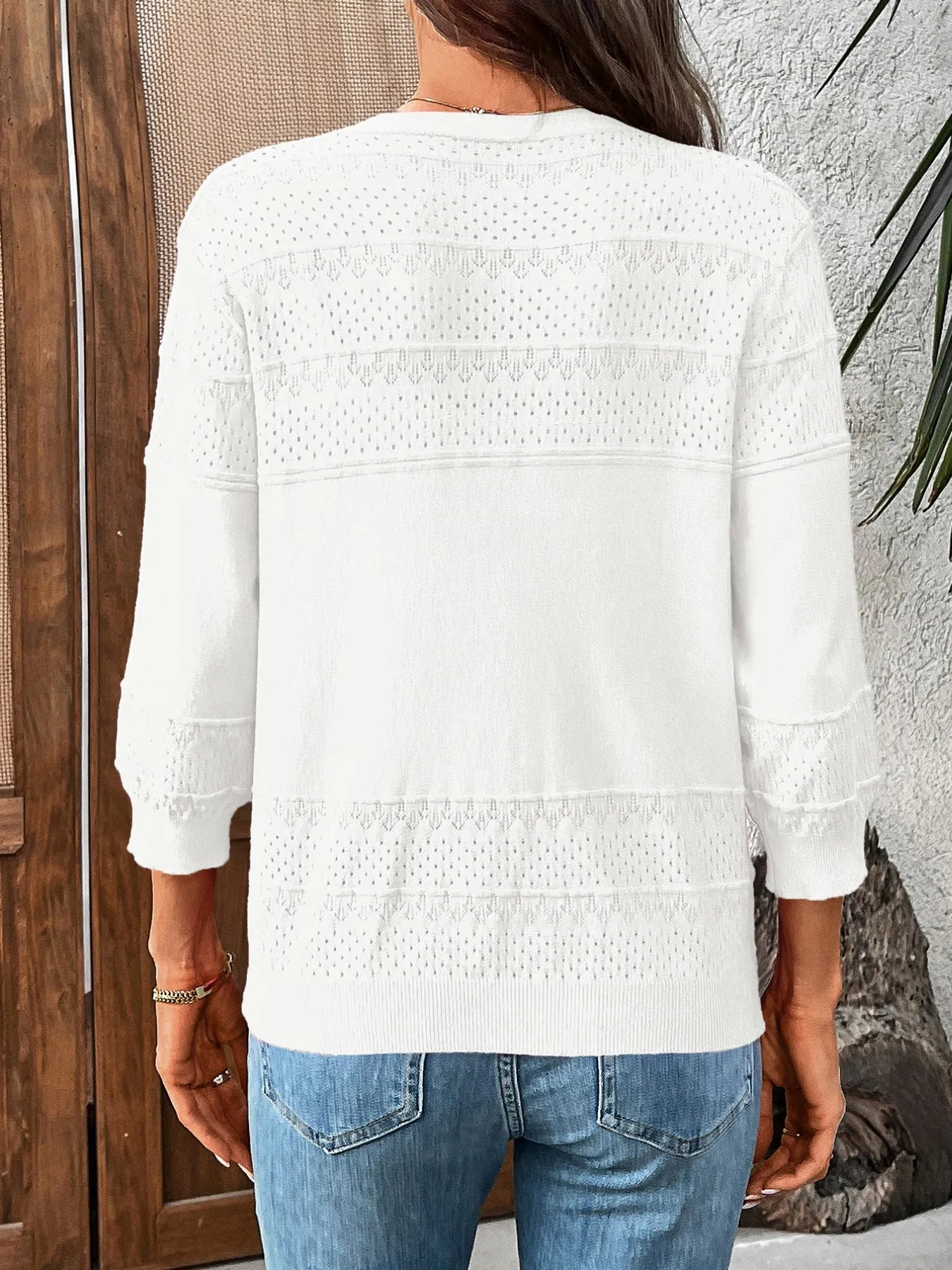 White textured cardigan with button details and 3/4 sleeves, rear view