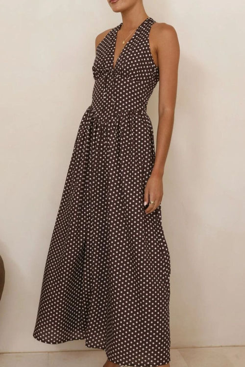 Dark polka dot halter neck maxi dress with fitted waist and flowing skirt