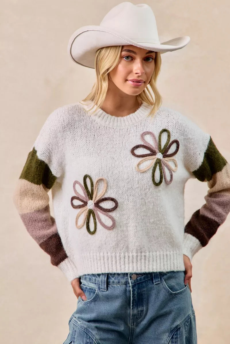 Ivory flower color block sweater with embroidered floral motifs and multi-color striped sleeves