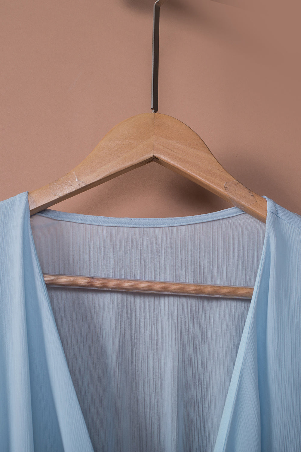 Sky blue dress back with smocked waist on hanger, showing sleeved yoke and neckline
