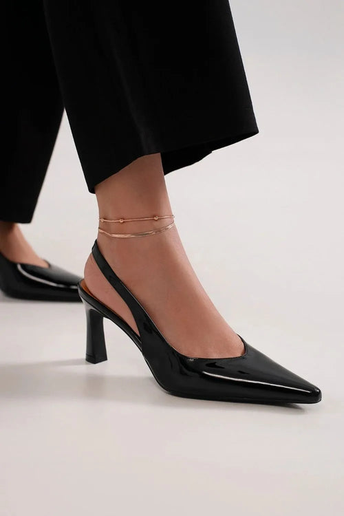 Black point-toe slingback pumps with thin ankle chain, glossy finish