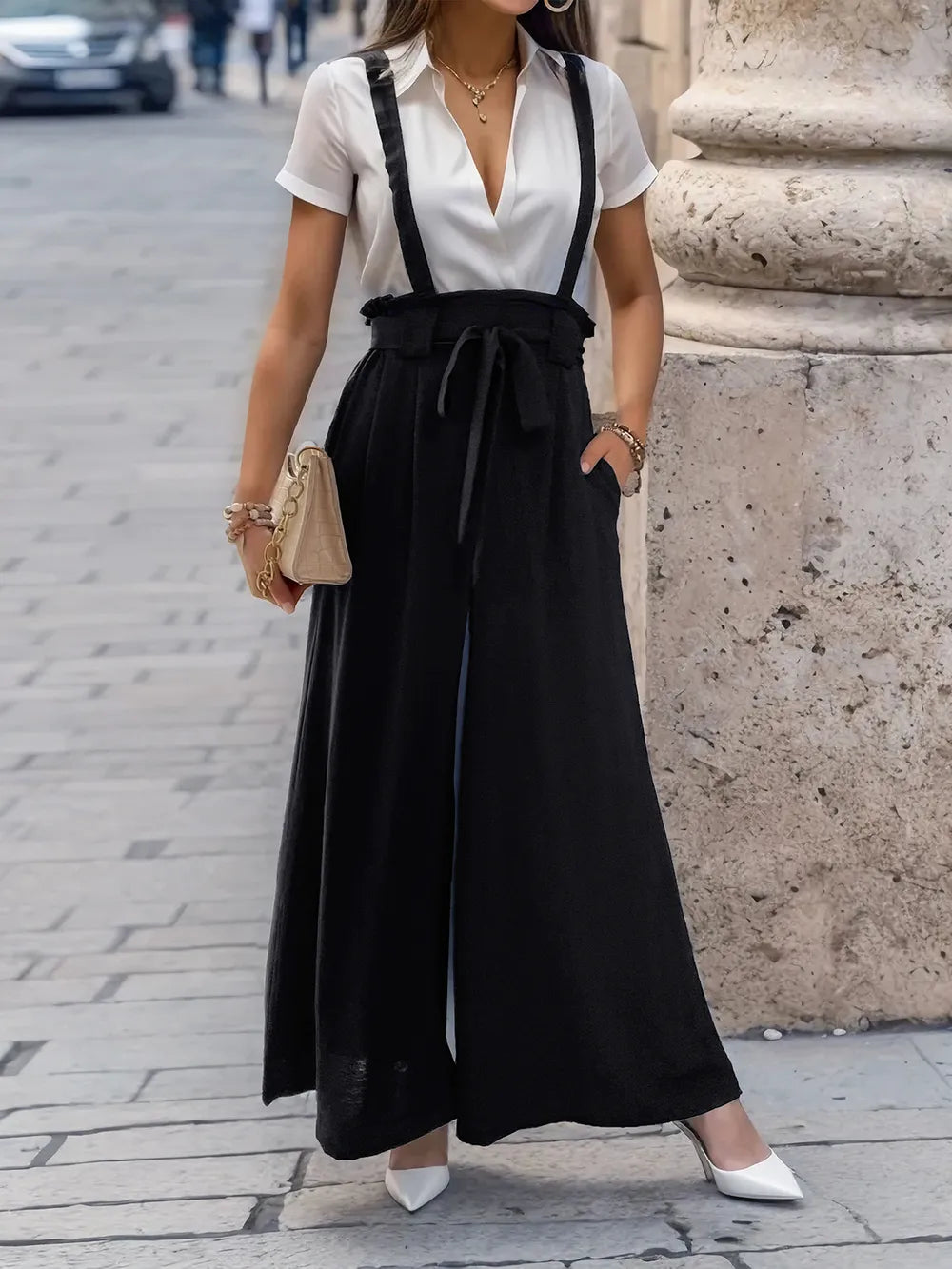 Black wide-leg pants with shoulder straps and bow-tied waist bib front