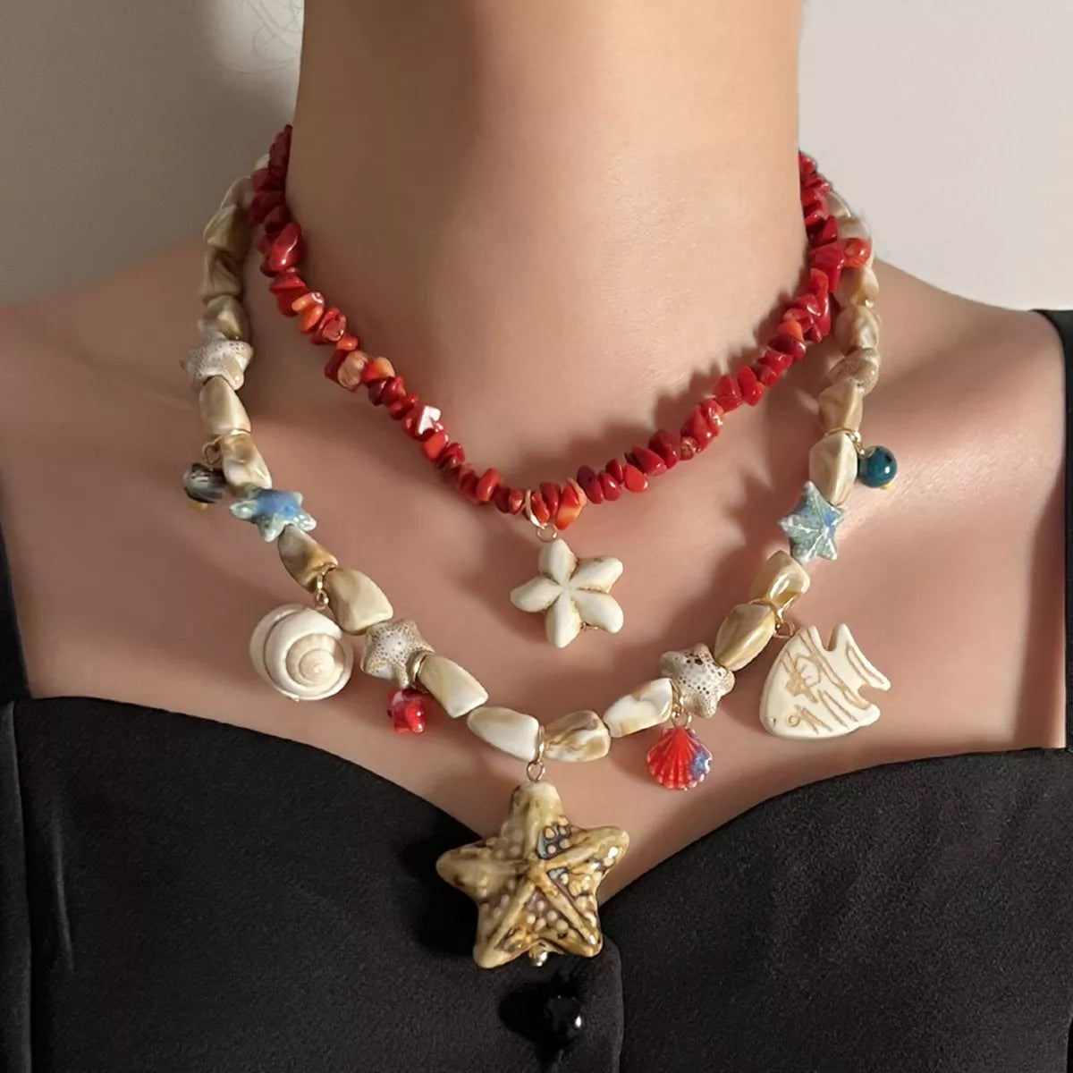 Red beaded multi-strand shell charm necklace with starfish and flower pendants