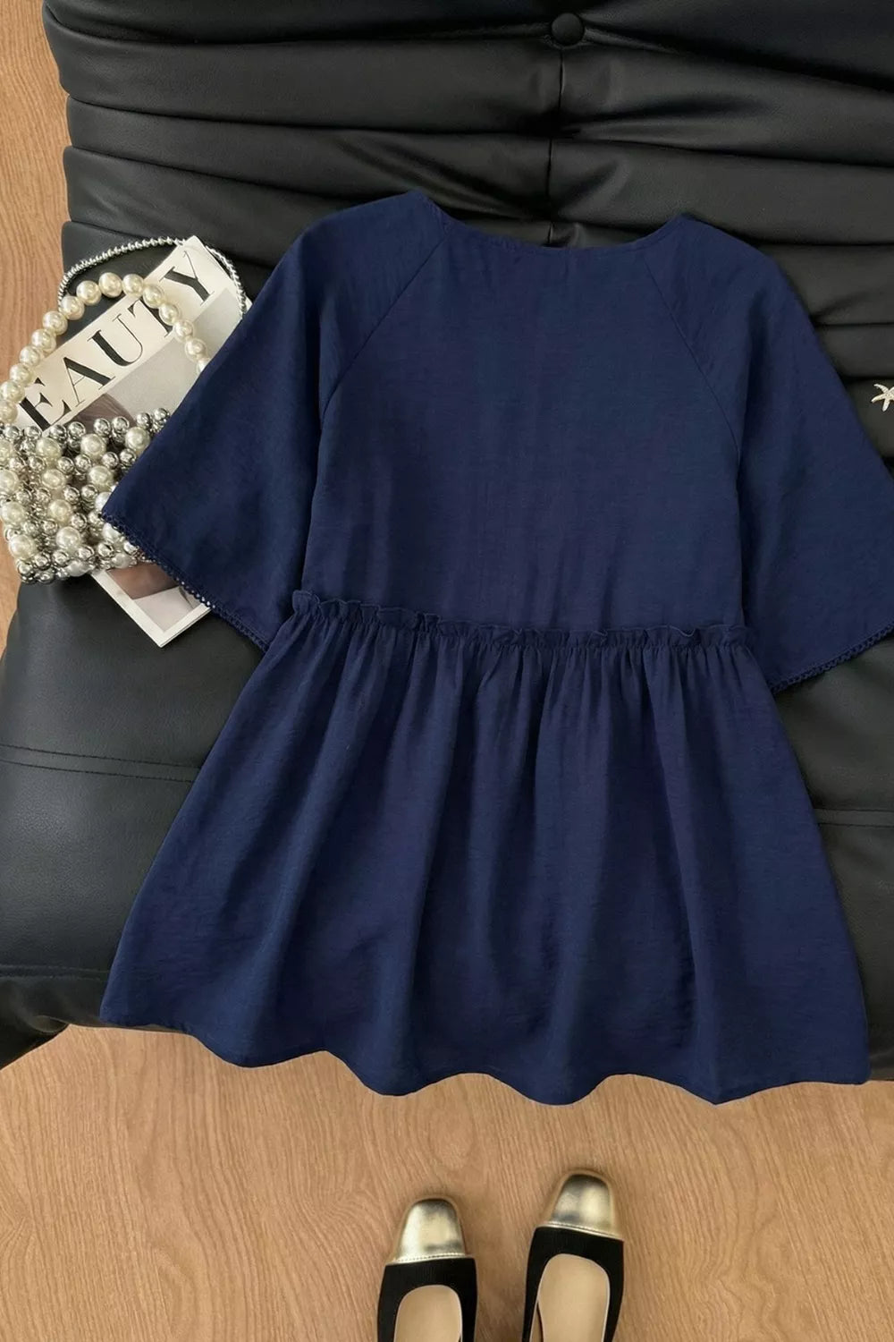 Ruffle Hem Tie-Neck Blouse in navy blue with buttoned detail