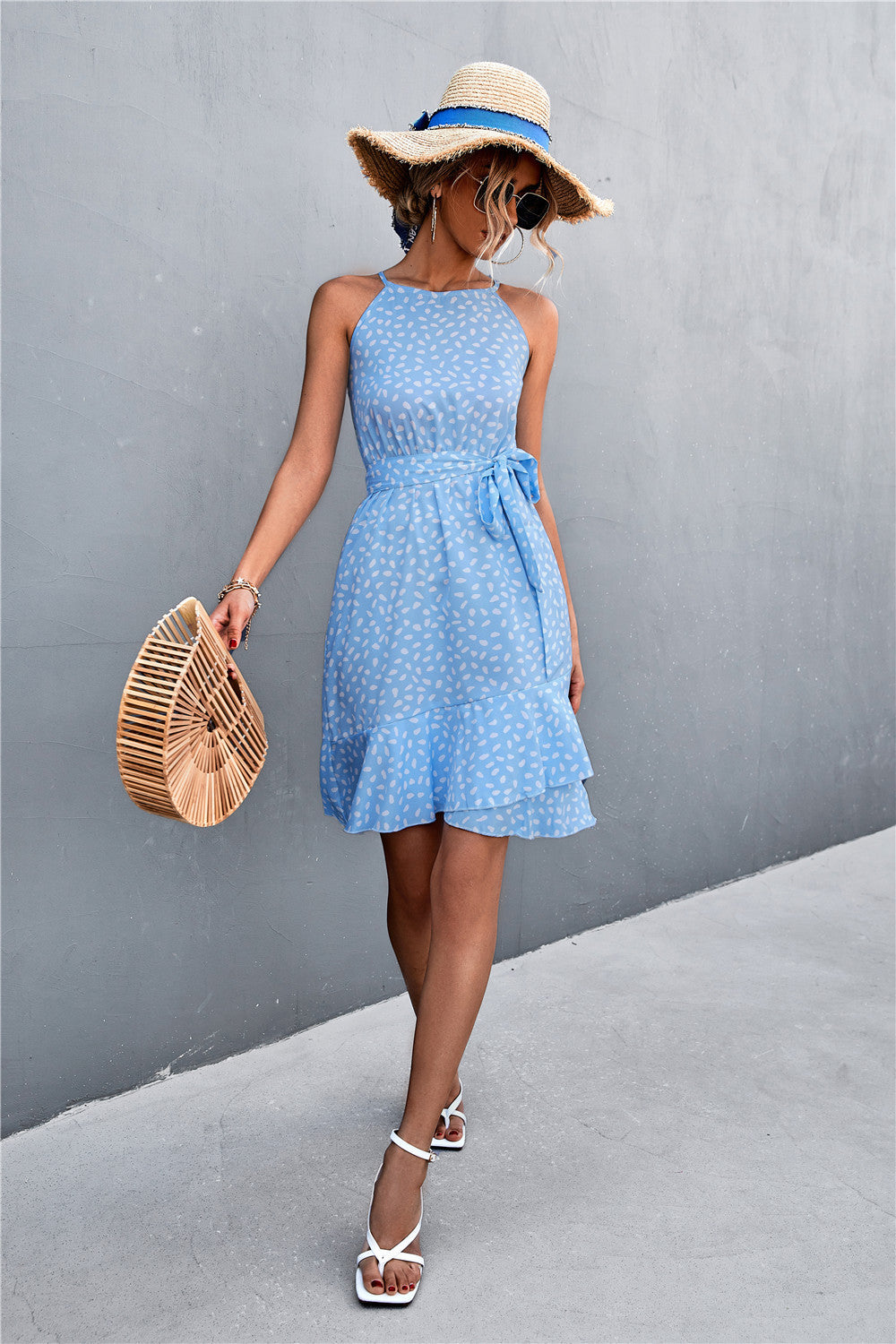 Pastel blue tie-waist sleeveless dress with white speckle print, bow-tied waist, ruffle hem