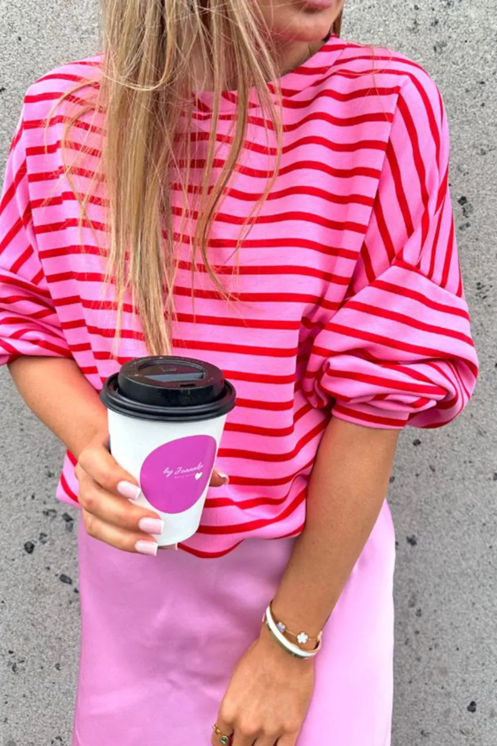 Hot pink striped round-neck long-sleeve sweatshirt with dropped shoulders and loose cuffs.