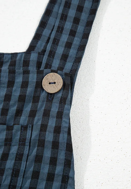 Dark blue plaid overalls detail with round button and gathered bib seam