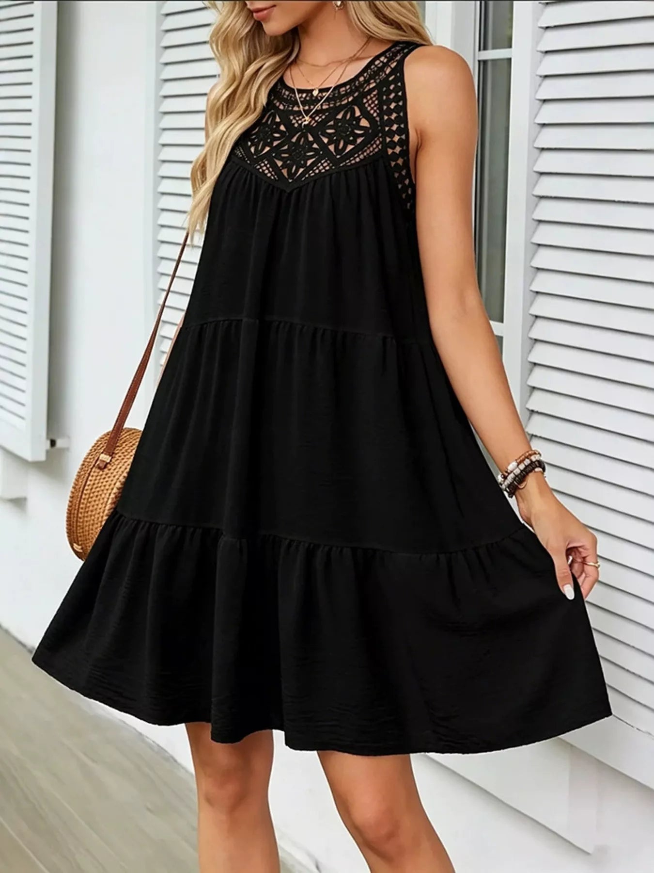Black sleeveless tiered dress with lace-pattern yoke