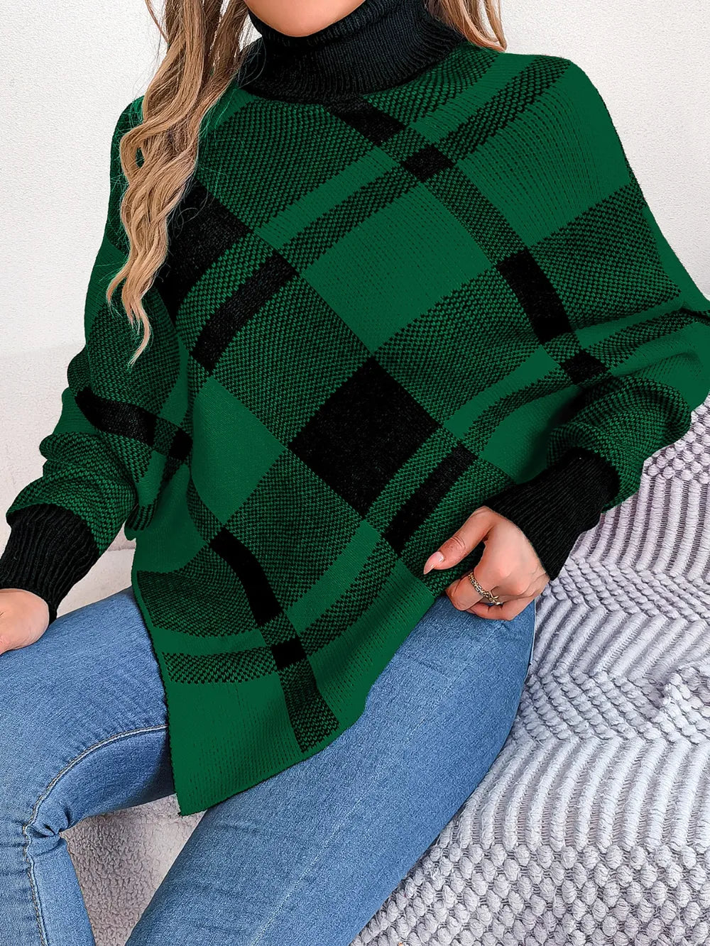 Plaid turtleneck batwing sweater in dark green with black plaid, long sleeves and high collar.