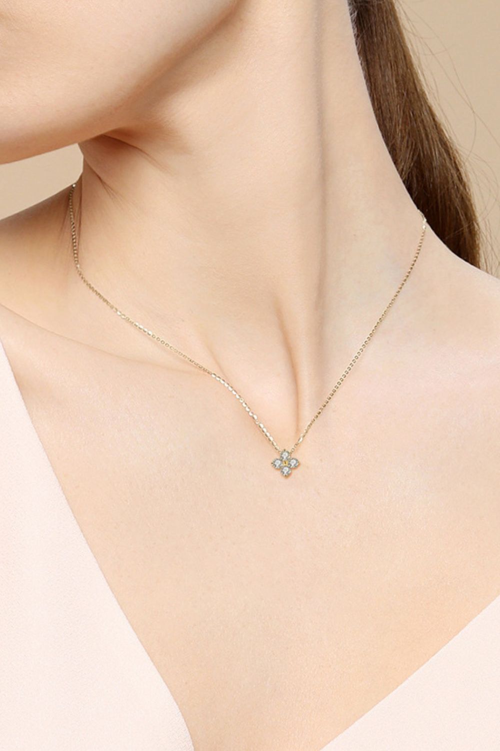 Silver-tone clover pendant necklace on a thin chain with a small blue-green center stone