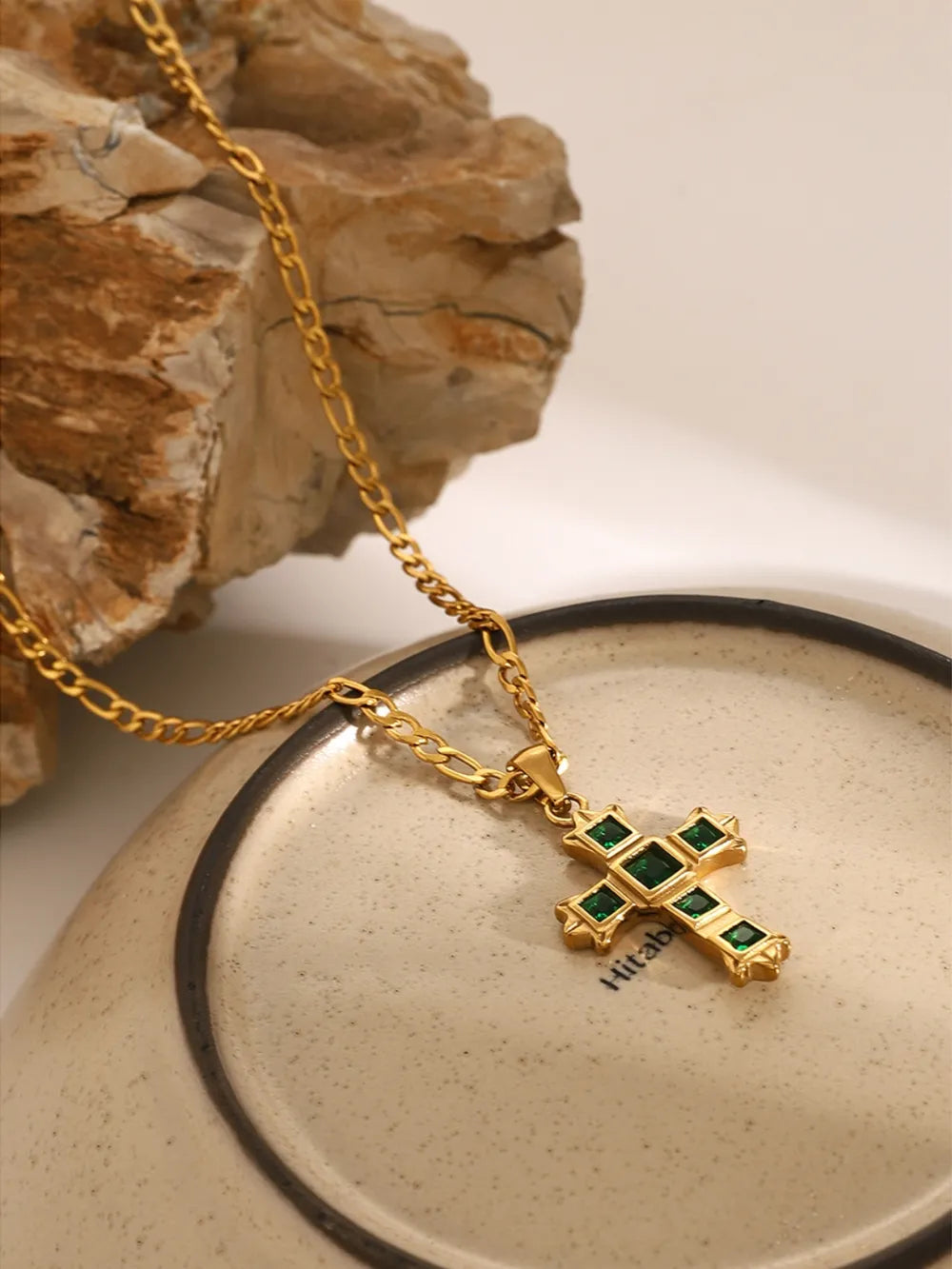 Gold-tone cross pendant necklace with green square stones and clear detailing