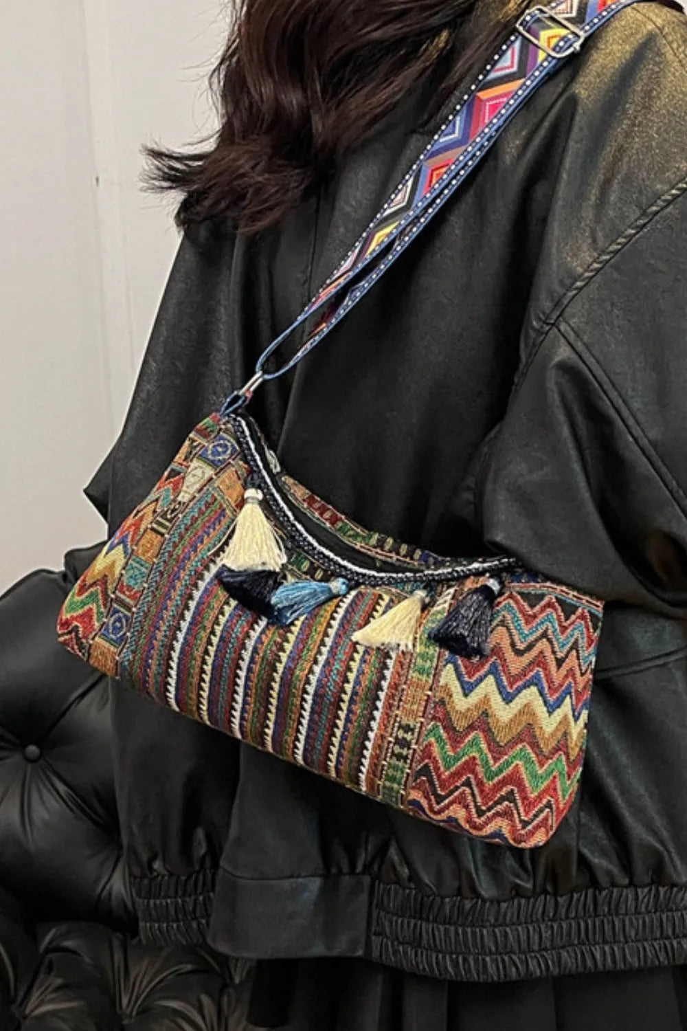 Tassel shoulder bag with adjustable strap, multicolor woven pattern with hanging tassels.