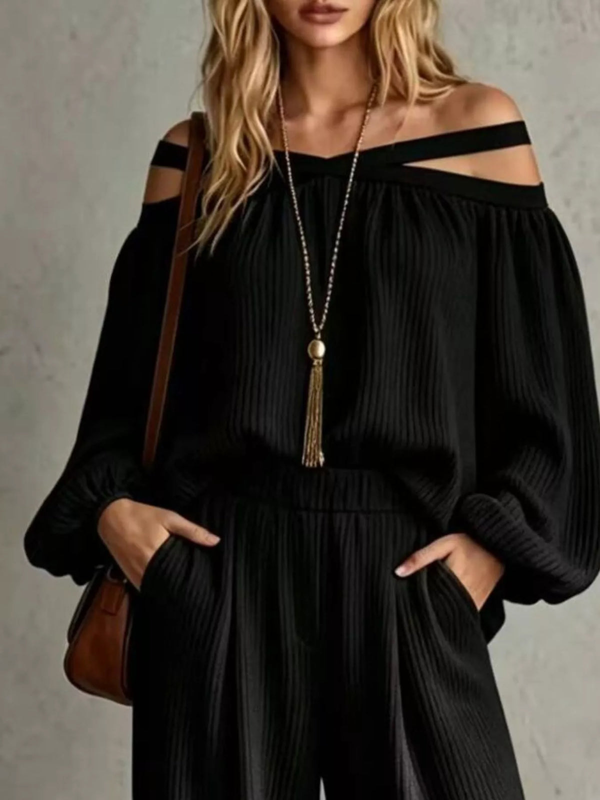 Black off-shoulder ribbed knit top with cutout strap neckline and wide-leg pants