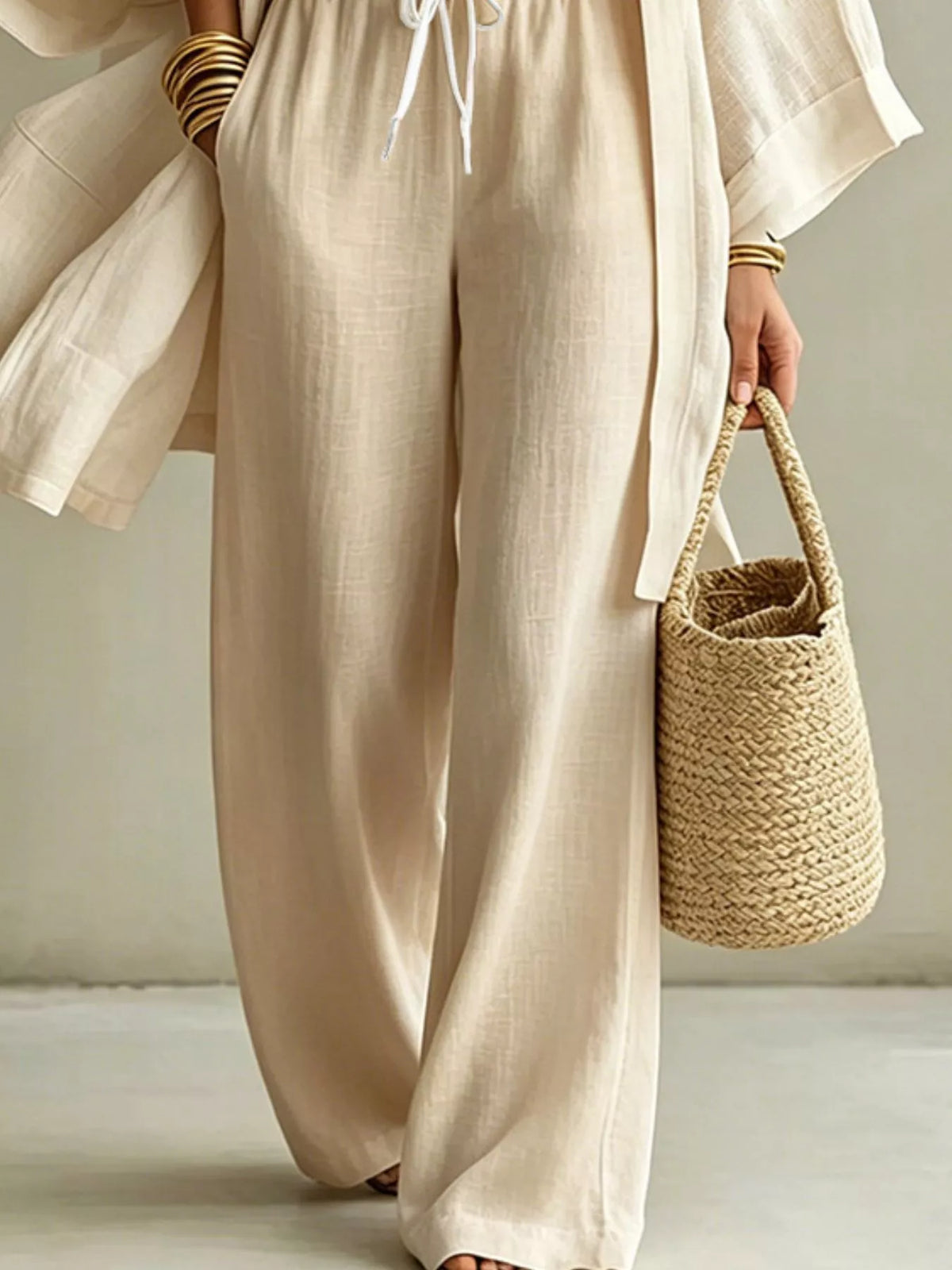 Off-white wide-leg pants with drawstring, matching three-piece set with open cardigan