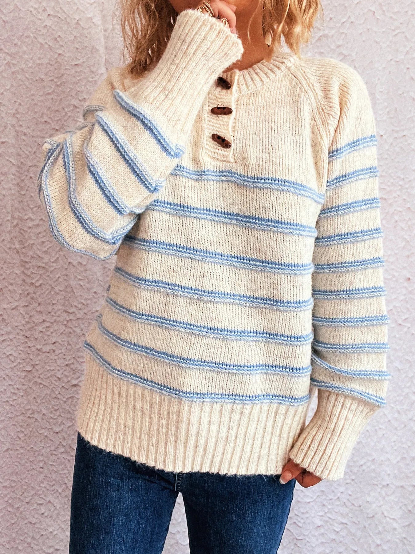 Cream striped long sleeve sweater with henley-style button front and wide ribbed cuffs