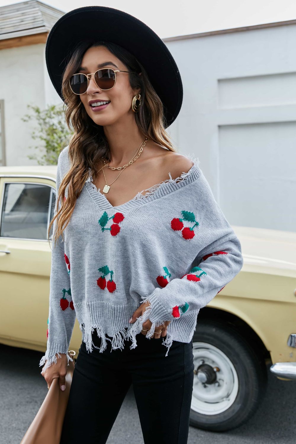 Sky blue V-neck sweater with cherry print and frayed trim at hem and cuffs