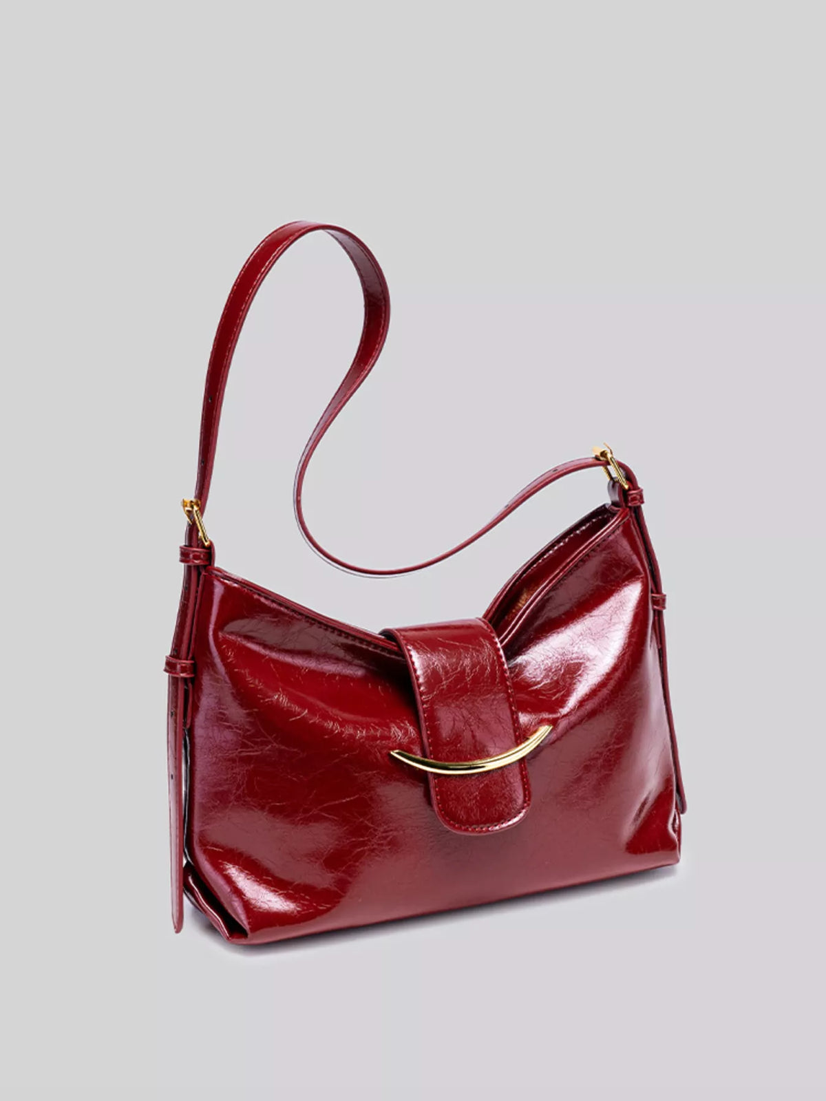 Wine red gloss vegan leather crescent shoulder bag with long shoulder strap and gold hardware