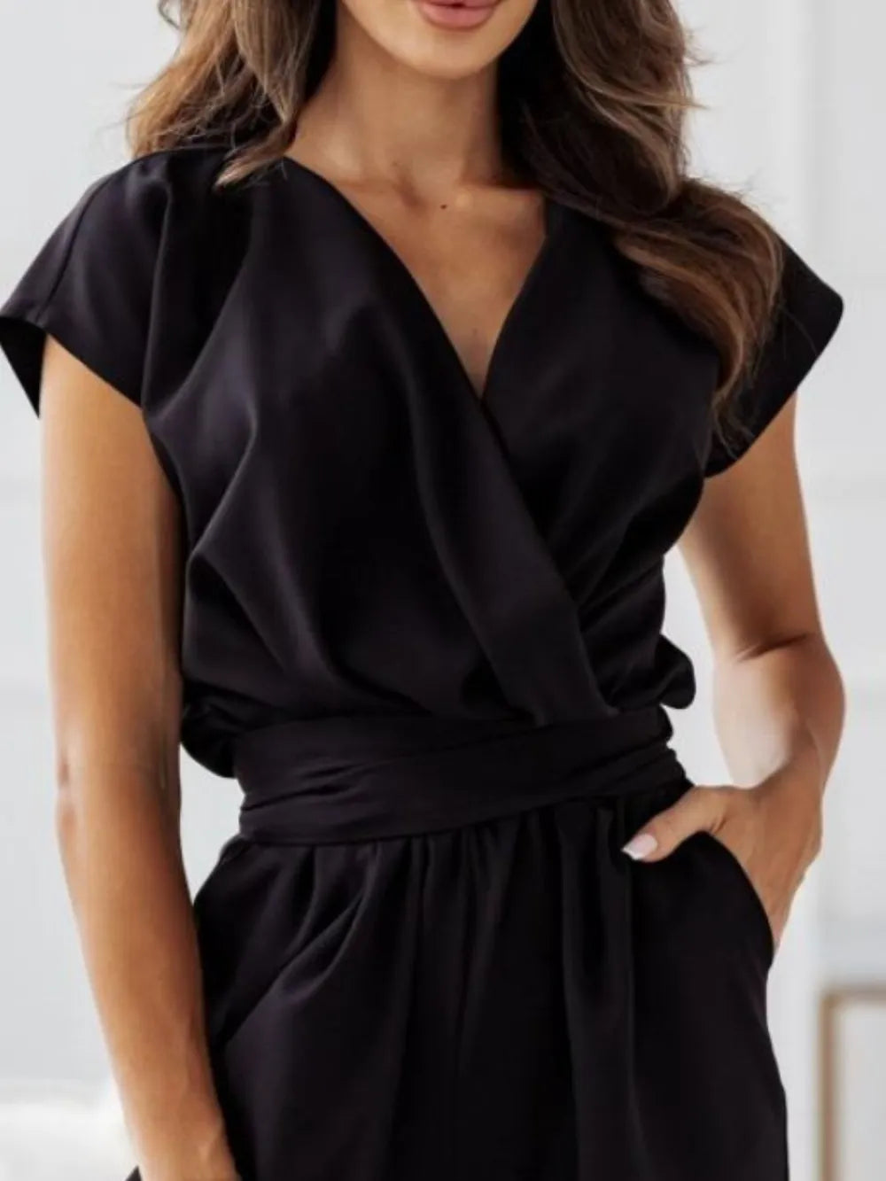Black surplice V-neck cap sleeve jumpsuit with cinched tie waist