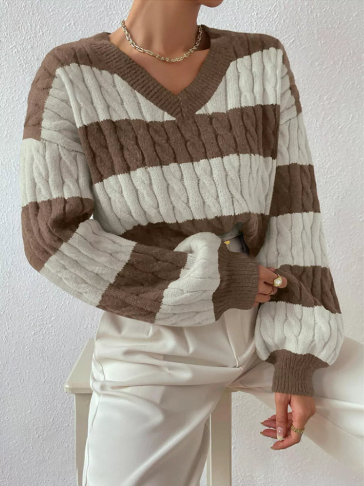 Brown and off-white striped cable knit V-neck sweater with long ribbed sleeves