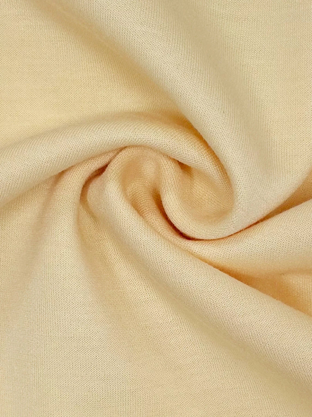 Light yellow knit fabric close-up with soft textured weave