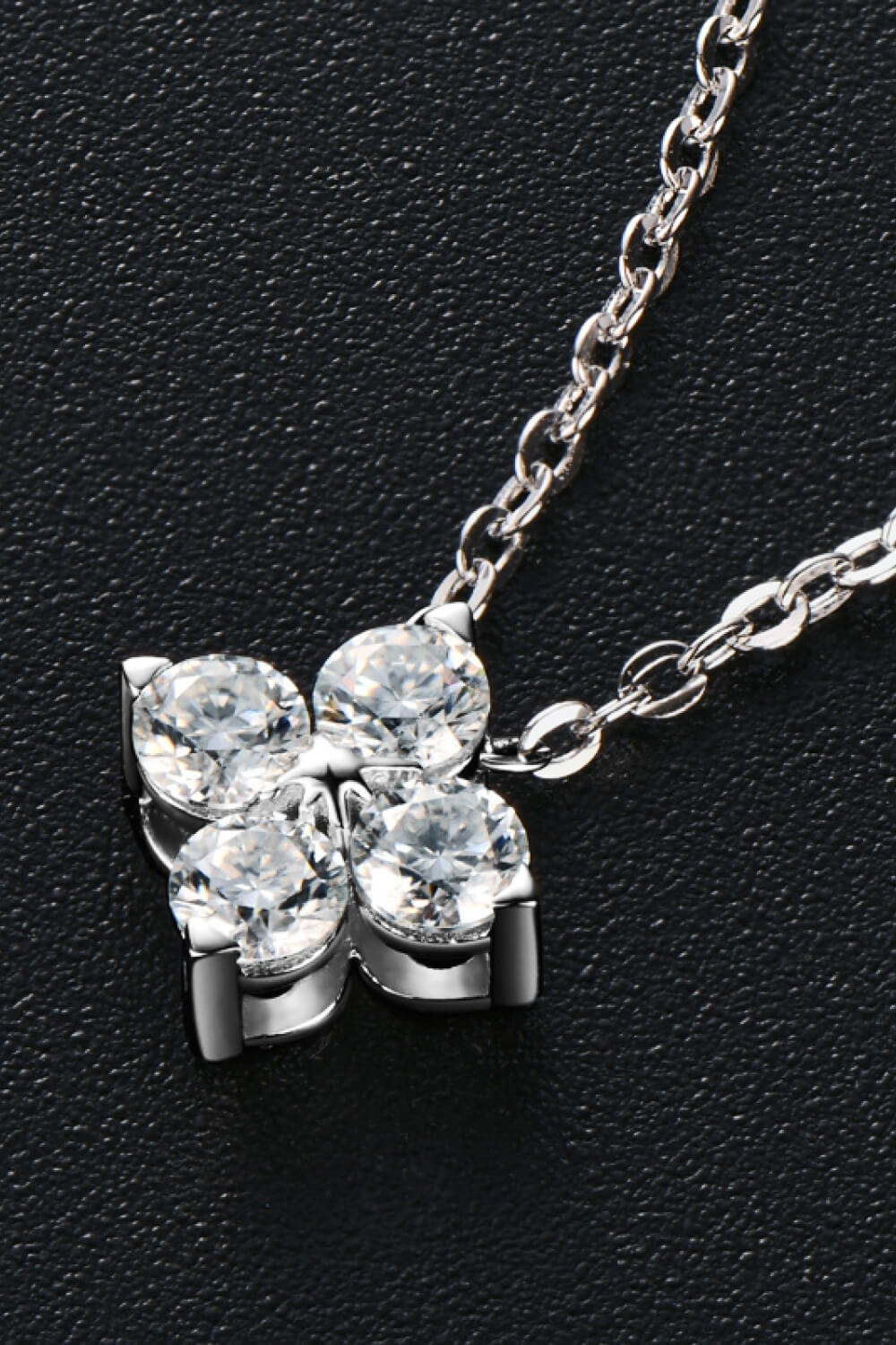 Silver-tone four-leaf clover pendant with four round stones and prong settings