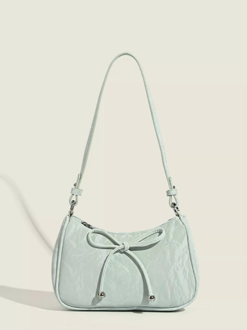 Light green bow-accent shoulder bag with adjustable straps and zip top