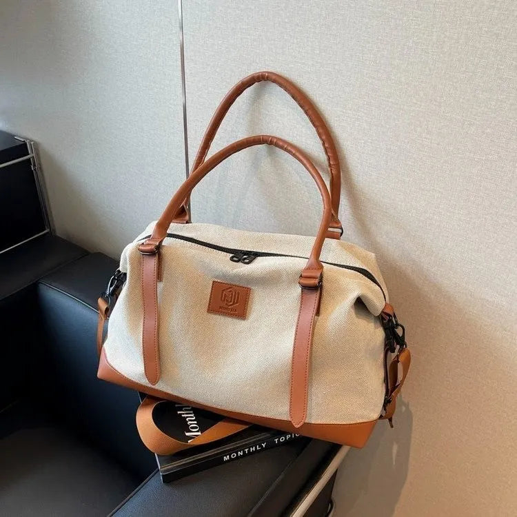 Large polyester duffle bag in cream with tan contrast handles and shoulder strap