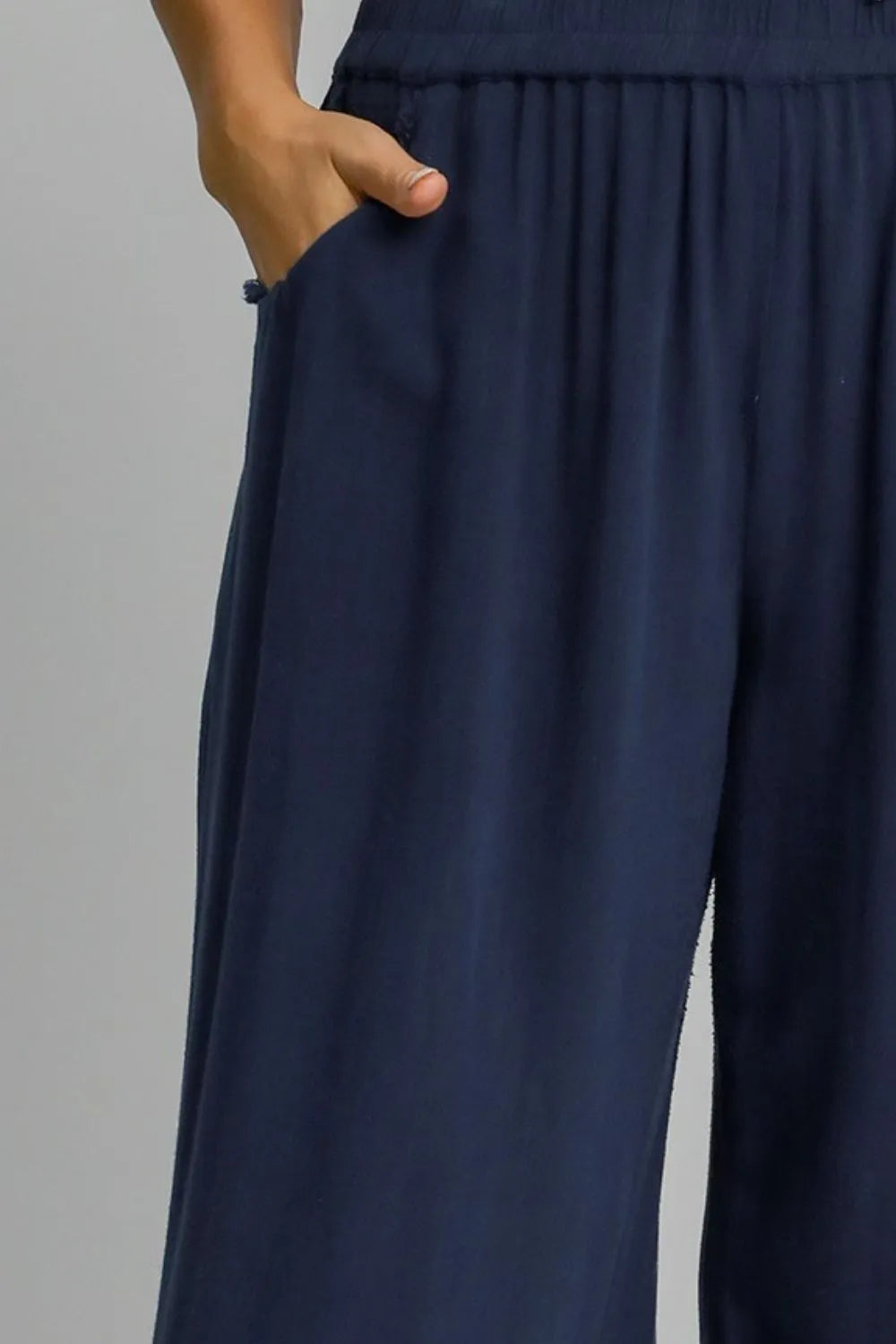 Dark blue wide-leg pants with gathered elastic waistband detail.