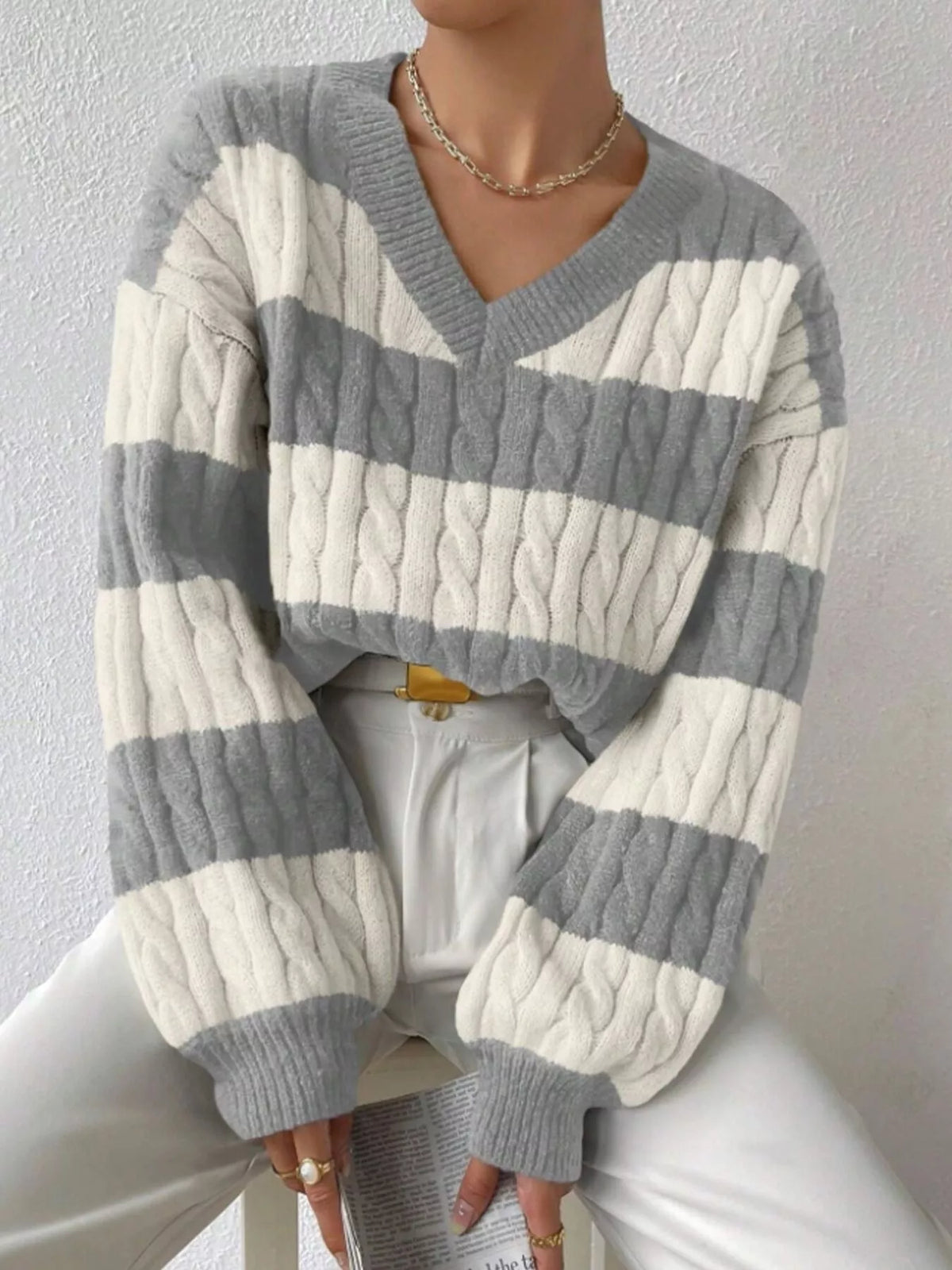 Light gray and off-white striped cable knit V-neck sweater with long ribbed sleeves