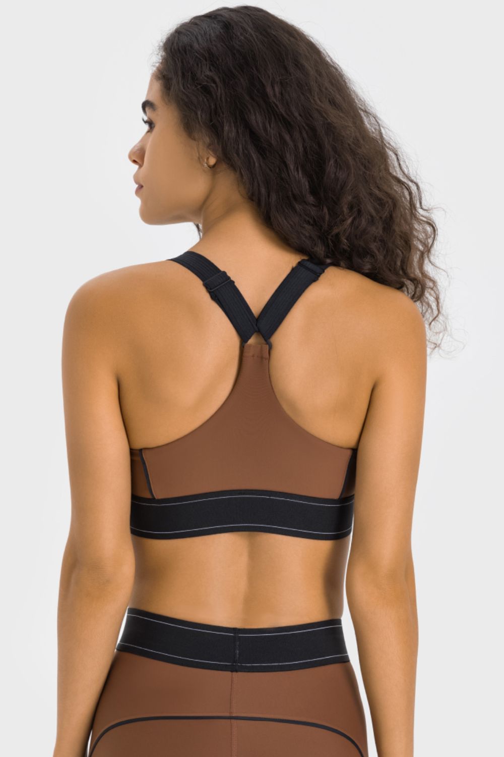 Back of brown sports bra with black contrast straps and band