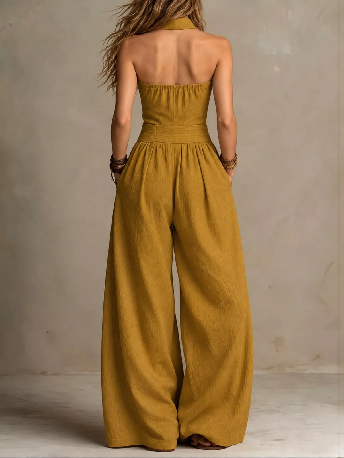 Yellow linen halter jumpsuit with open back and wide-leg trousers