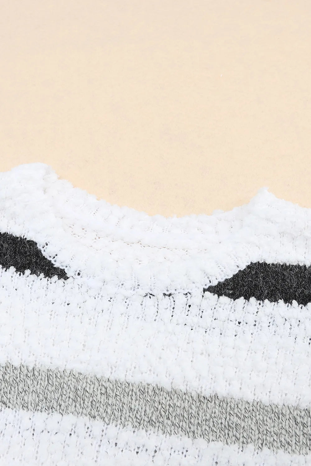 White knit crew neckline sweater with black and tan stripe band across the chest
