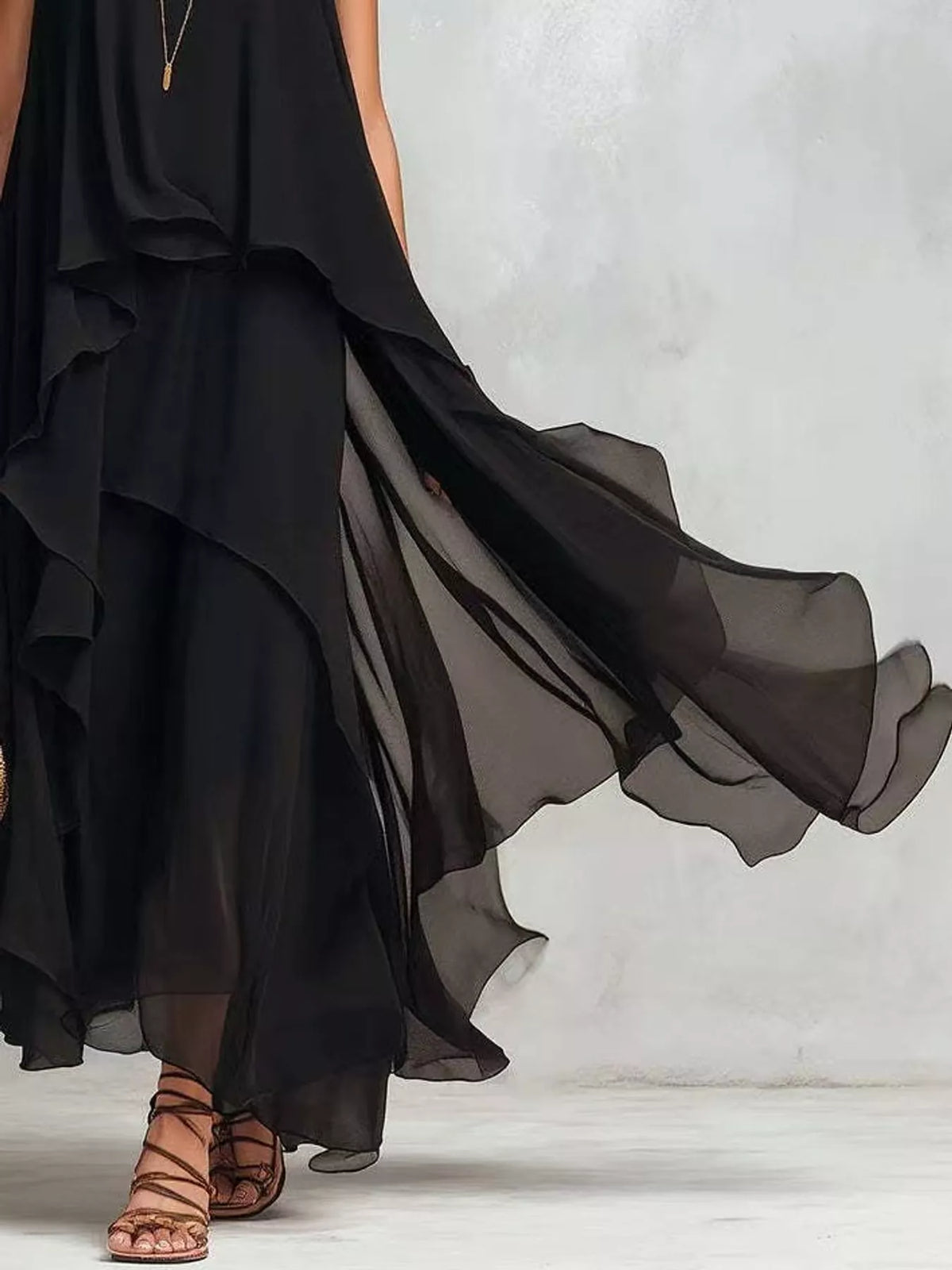 Black sleeveless maxi dress with cascading ruffled tiers and sheer layered hem