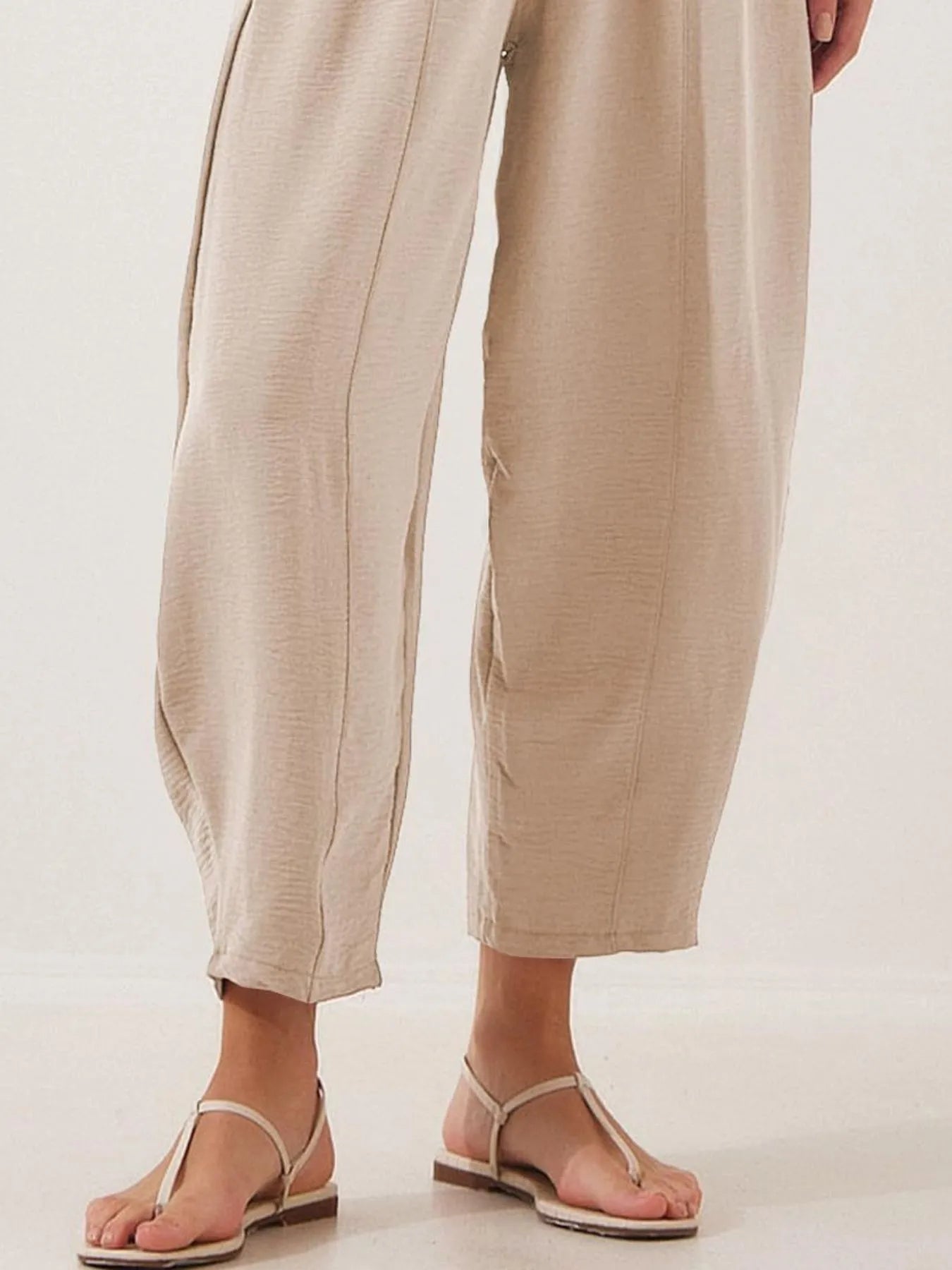 Beige cropped wide-leg pants with elastic drawstring waistband and wide hems