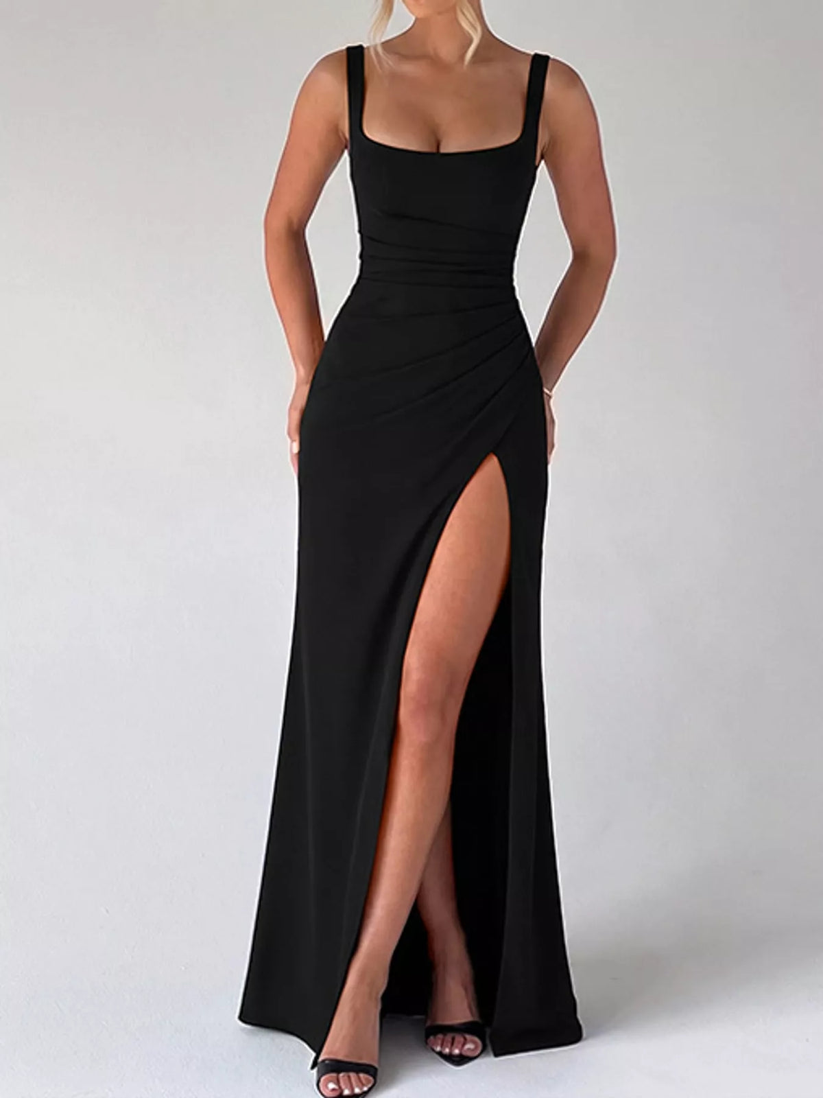 Black ruched evening maxi dress with square neckline, thin straps, and front leg slit